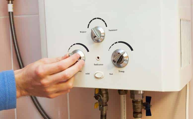 Person adjusting Flow Rate Limitations in Tankless Water Heaters.