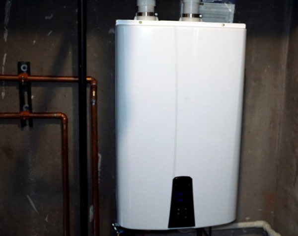 A tankless water heater installed in a garage.